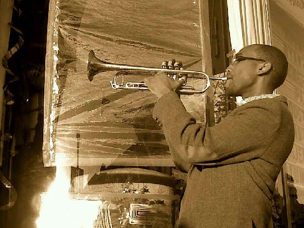 Sepia portrait of a young man in profile playing the trumpet