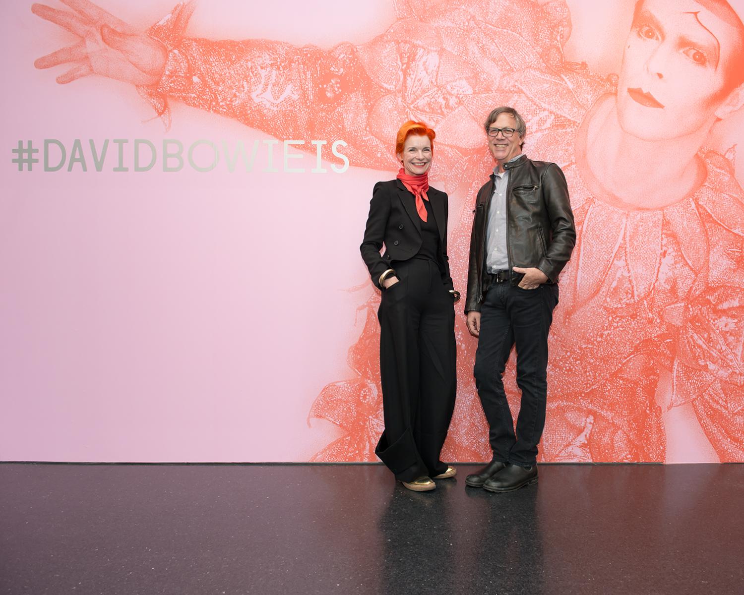 A woman and man posing at the entrance of the exhibition *David Bowie Is*.