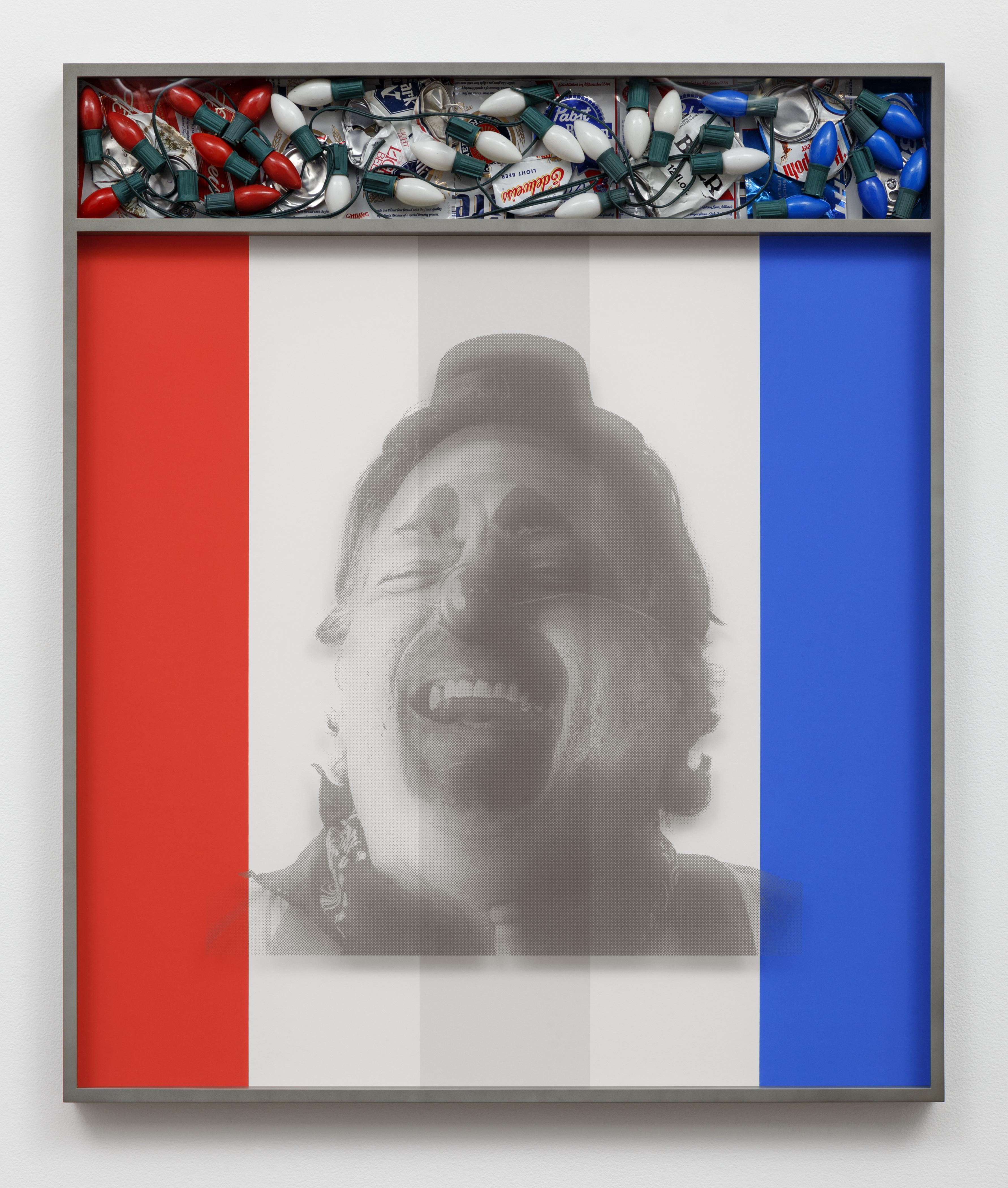 A black and white image of a laughing clown appears on a panel of red, white, and blue vertical stripes inside a gray frame. Inside the frame, above the image, a cubbyhole is filled with holiday lights and campaign buttons in red, white, and blue sections that mirror the stripes below.