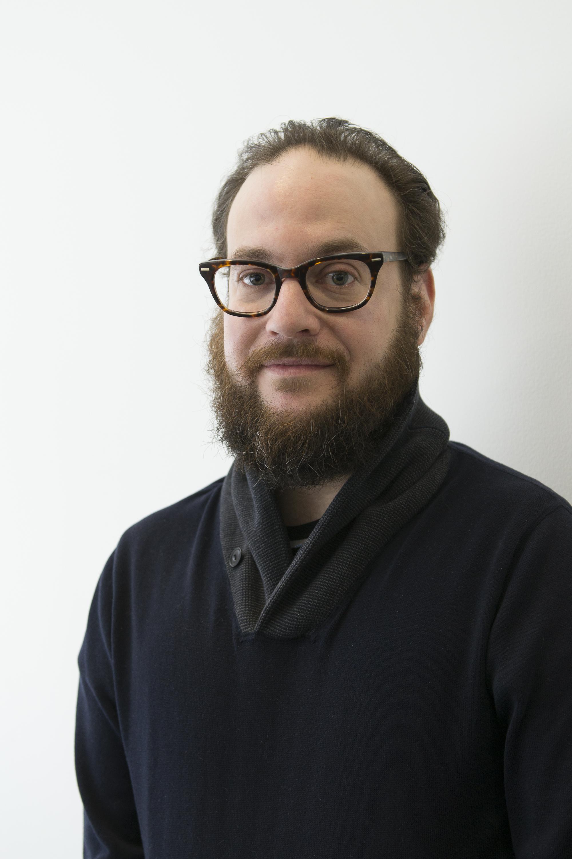 A portrait of a bearded man with glasses