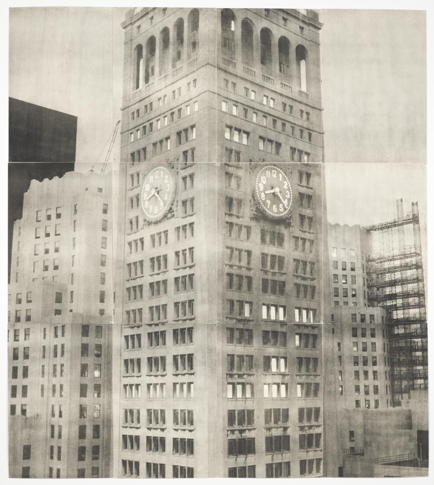 An aged black-and-white photograph shows tall buildings, with the tallest in the center displaying two analog clock faces showing the time as 8:22.