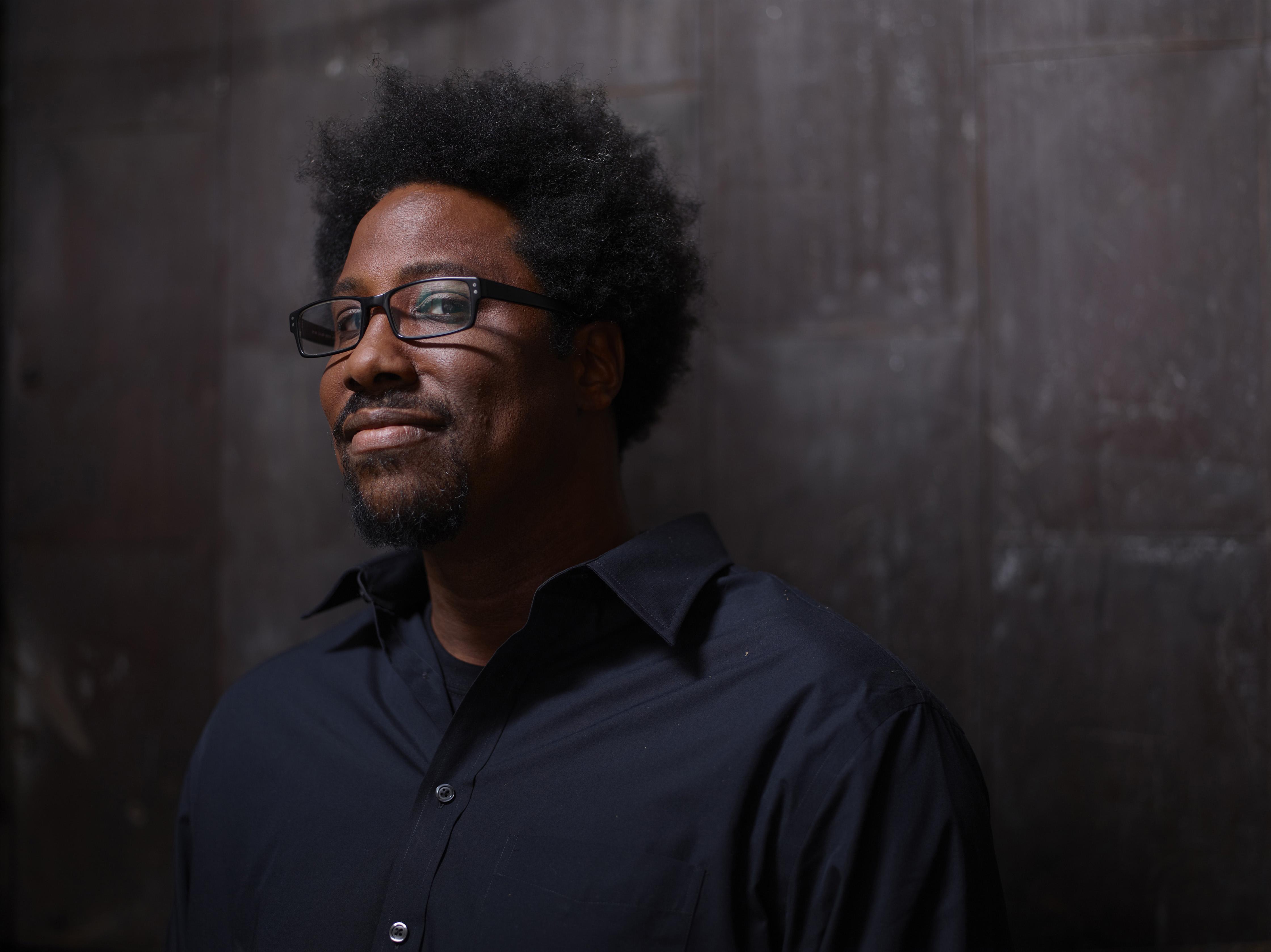 Portrait of man with glasses and an afro