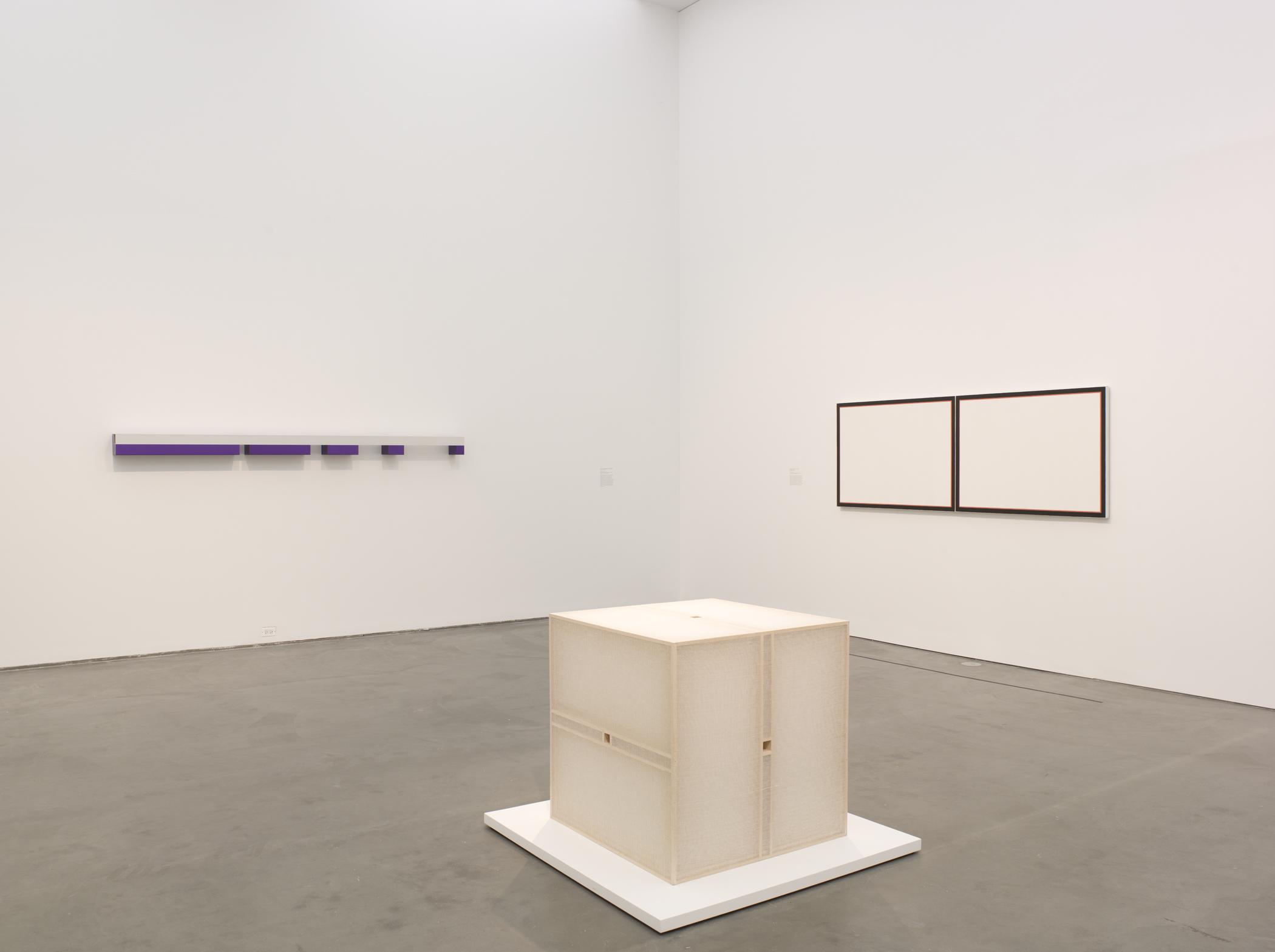 Gallery view of three minimalist artworks on the walls and floor