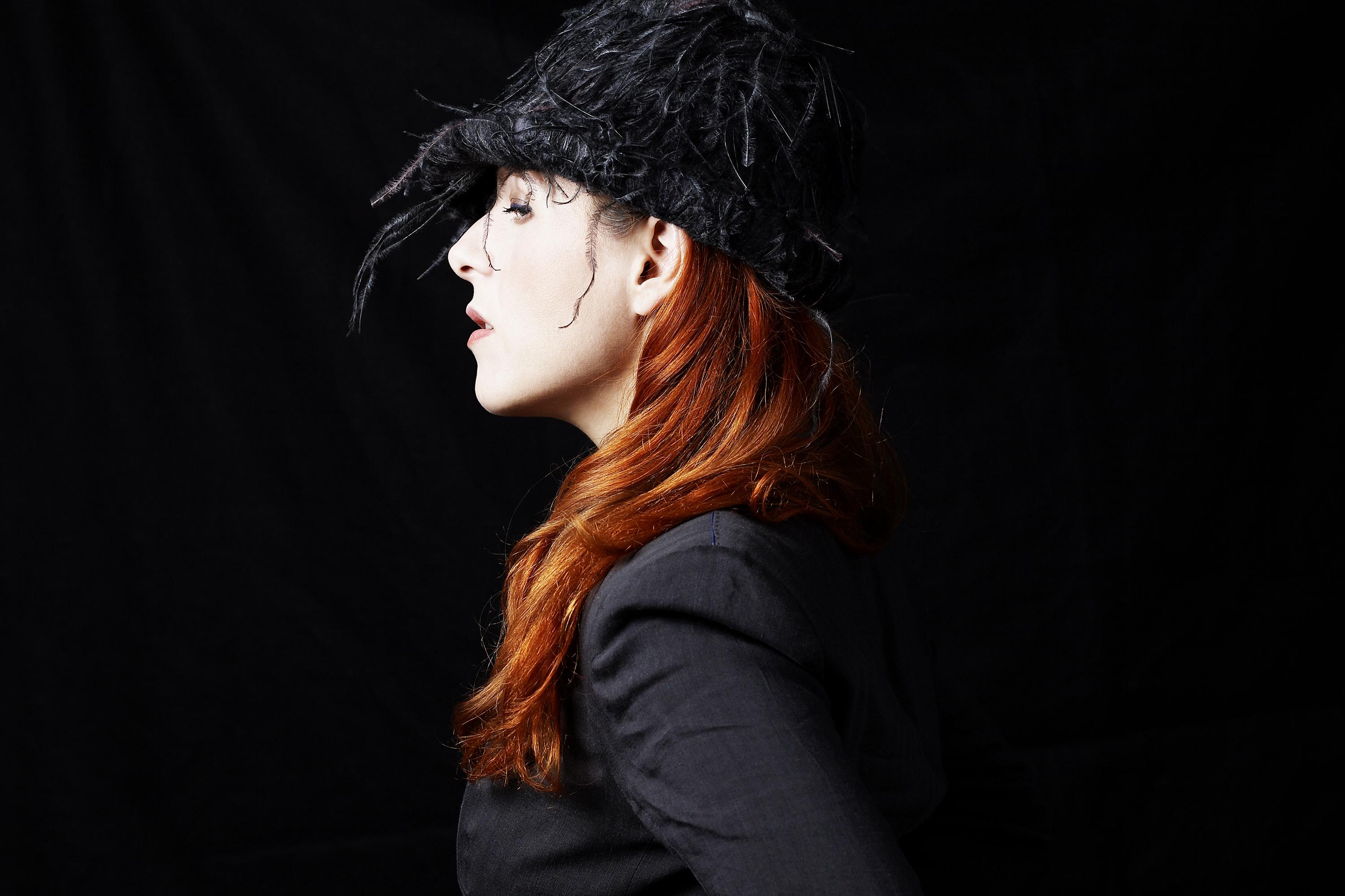 A close-up portrait shows musician Neko Case in profile.