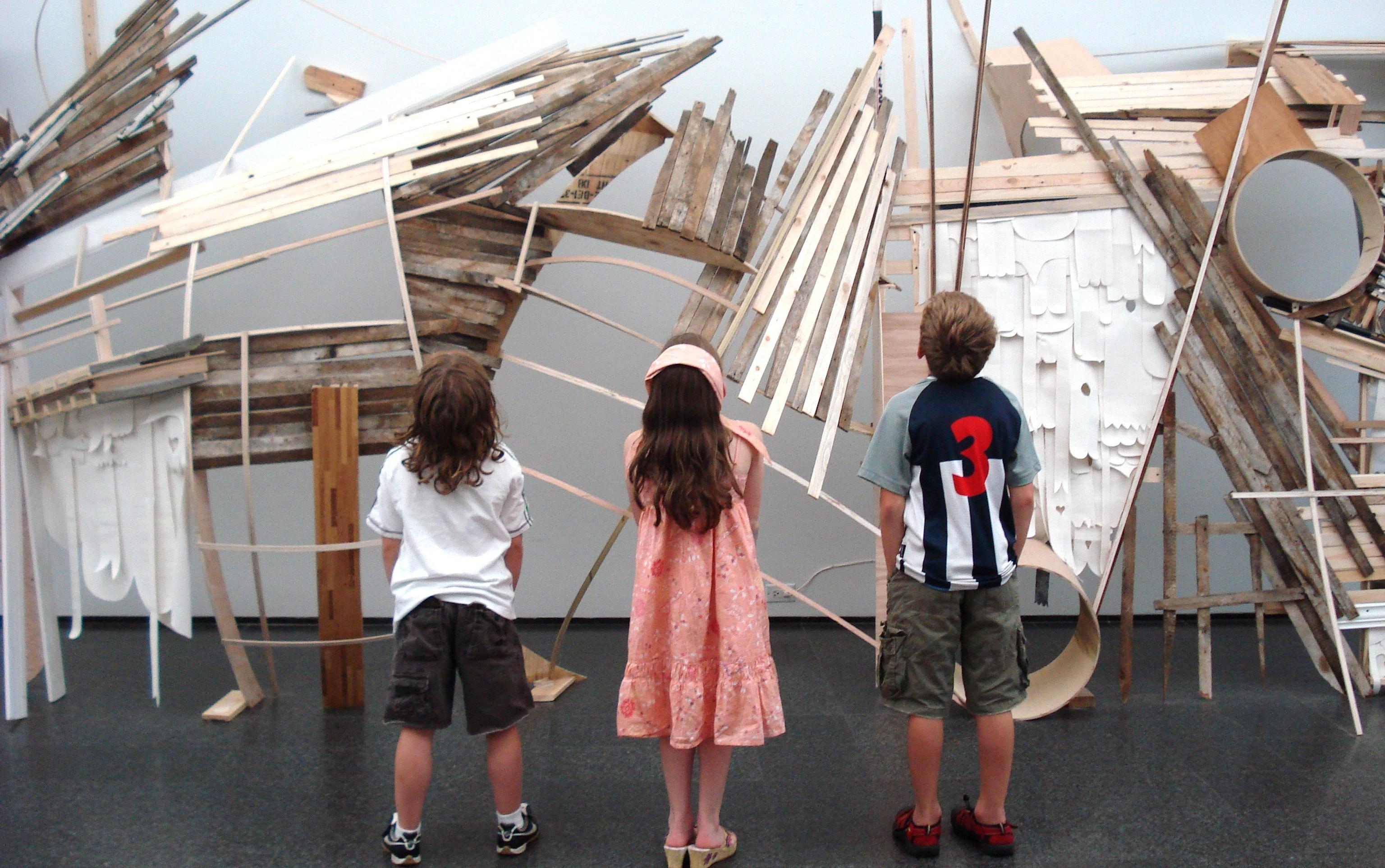 three children view an art installation