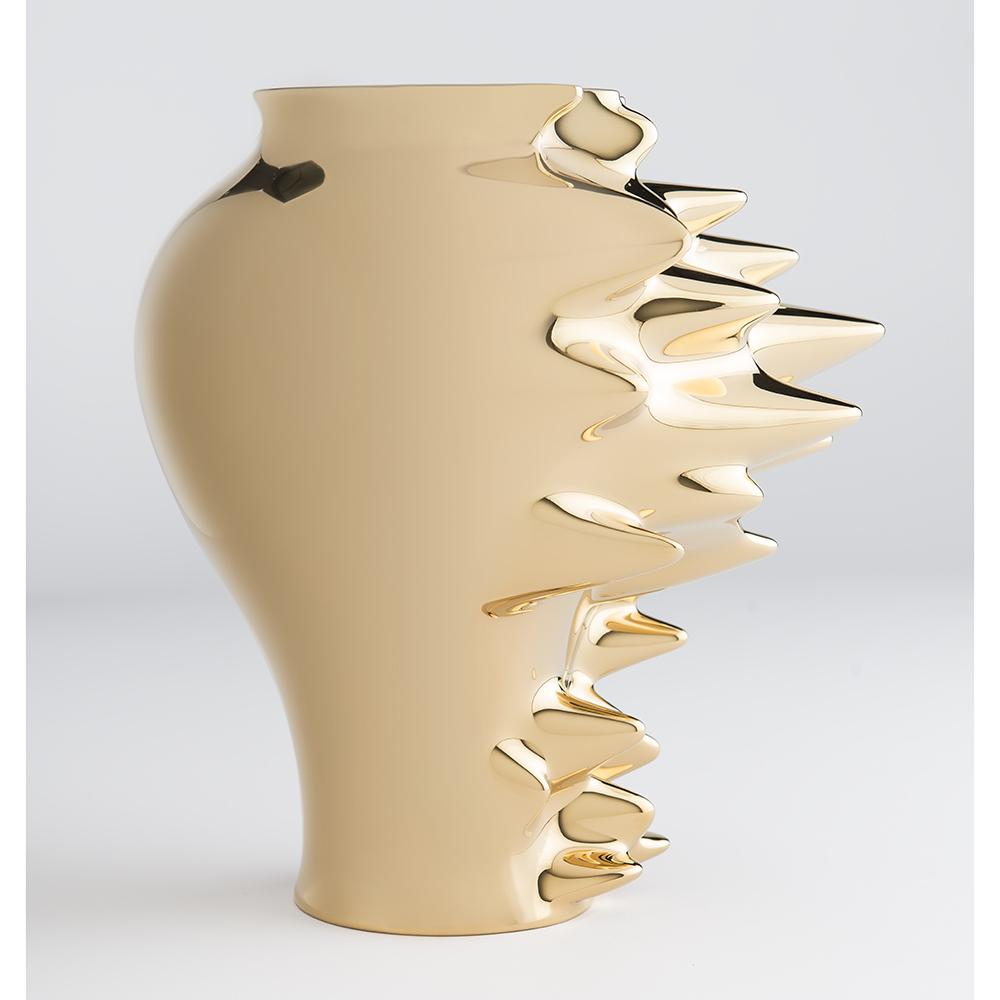 This polished gold vase is sculpted to appear to be moving quickly to the left, such that the material of the vase is being pulled to the right of the frame like a motion blur.