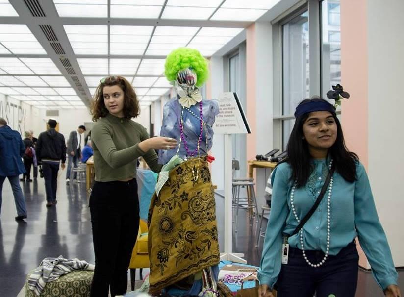 Two teen girls stand with a garishly dressed mannequin in the MCA's fourth-floor lobby.