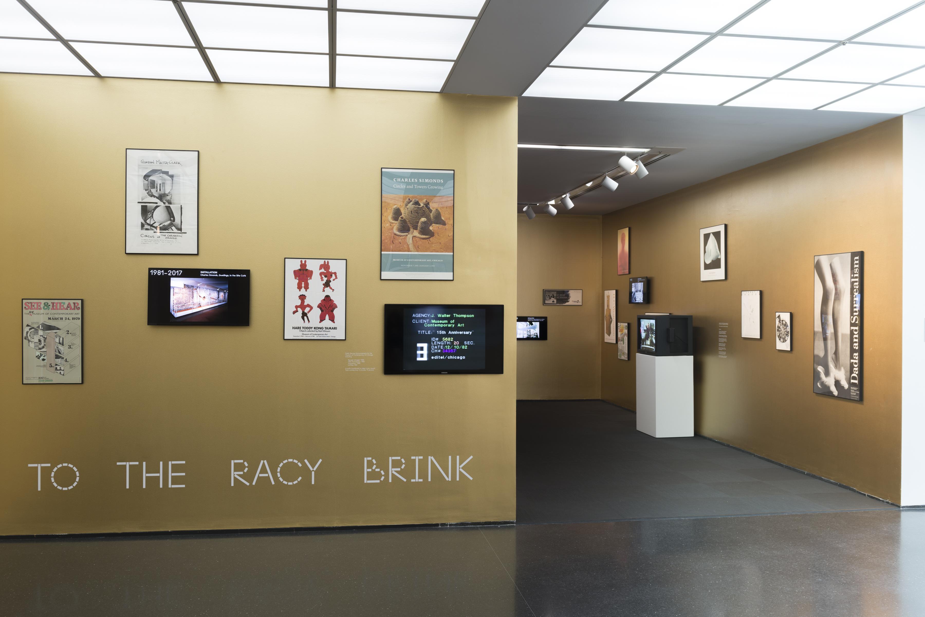 View of gallery with vinyl wall lettering that reads 'TO THE RACY BRINK'