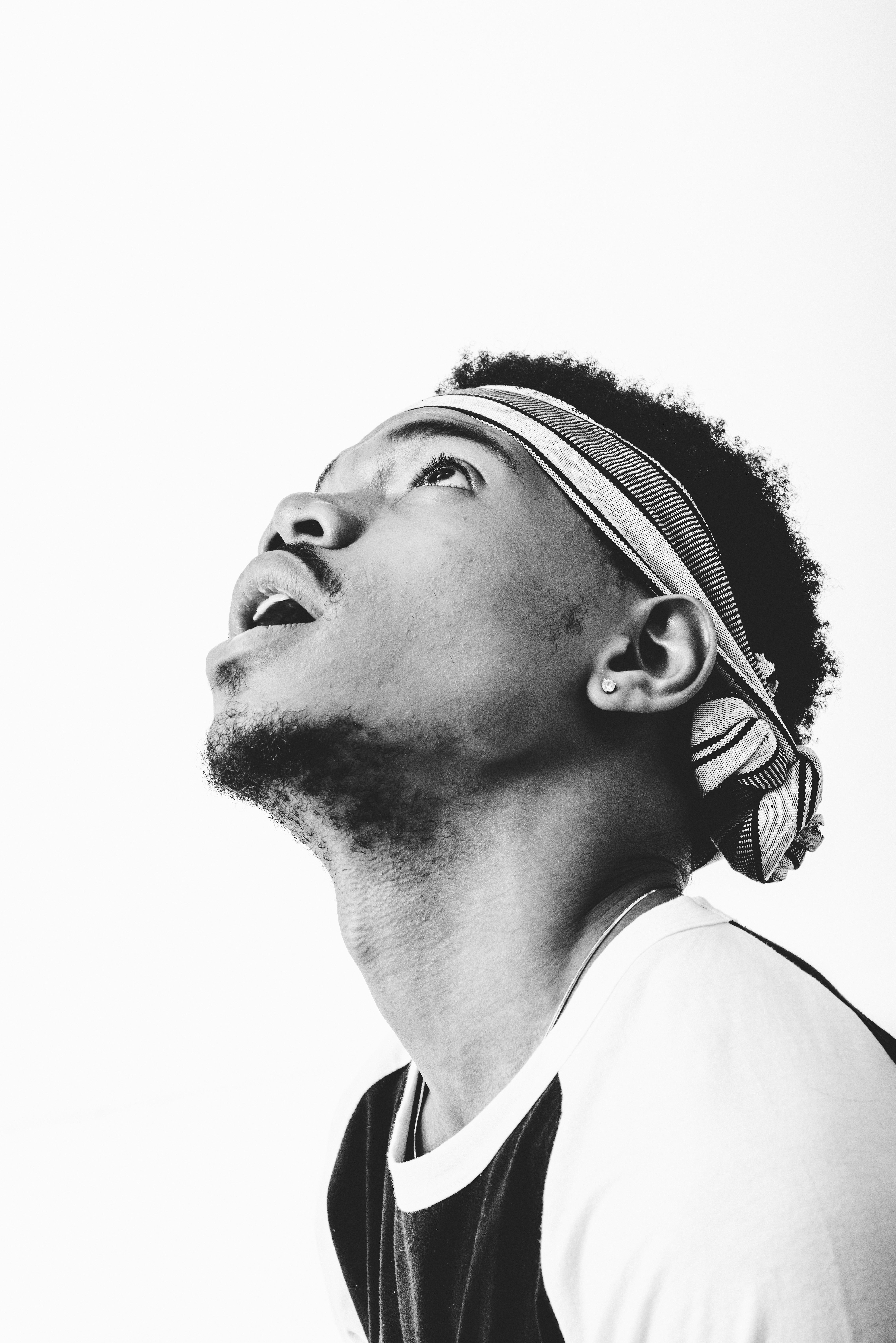 Chance the Rapper sits for a monochrome portrait looking up and away