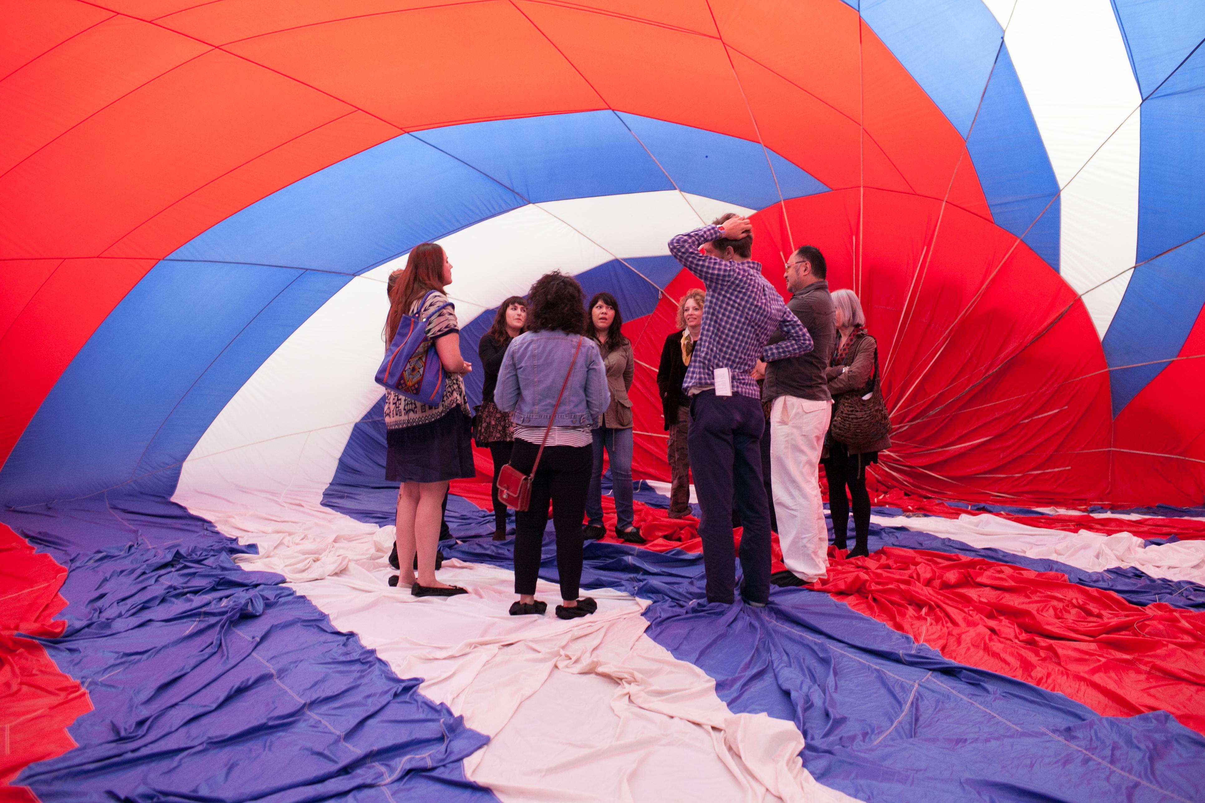 A group of people stands inside a large, fabric structure with red, white, and blue stripes.