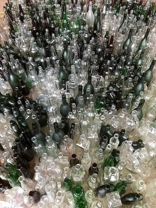 A photo of hundreds of bottles of different colors, shapes, and sizes.