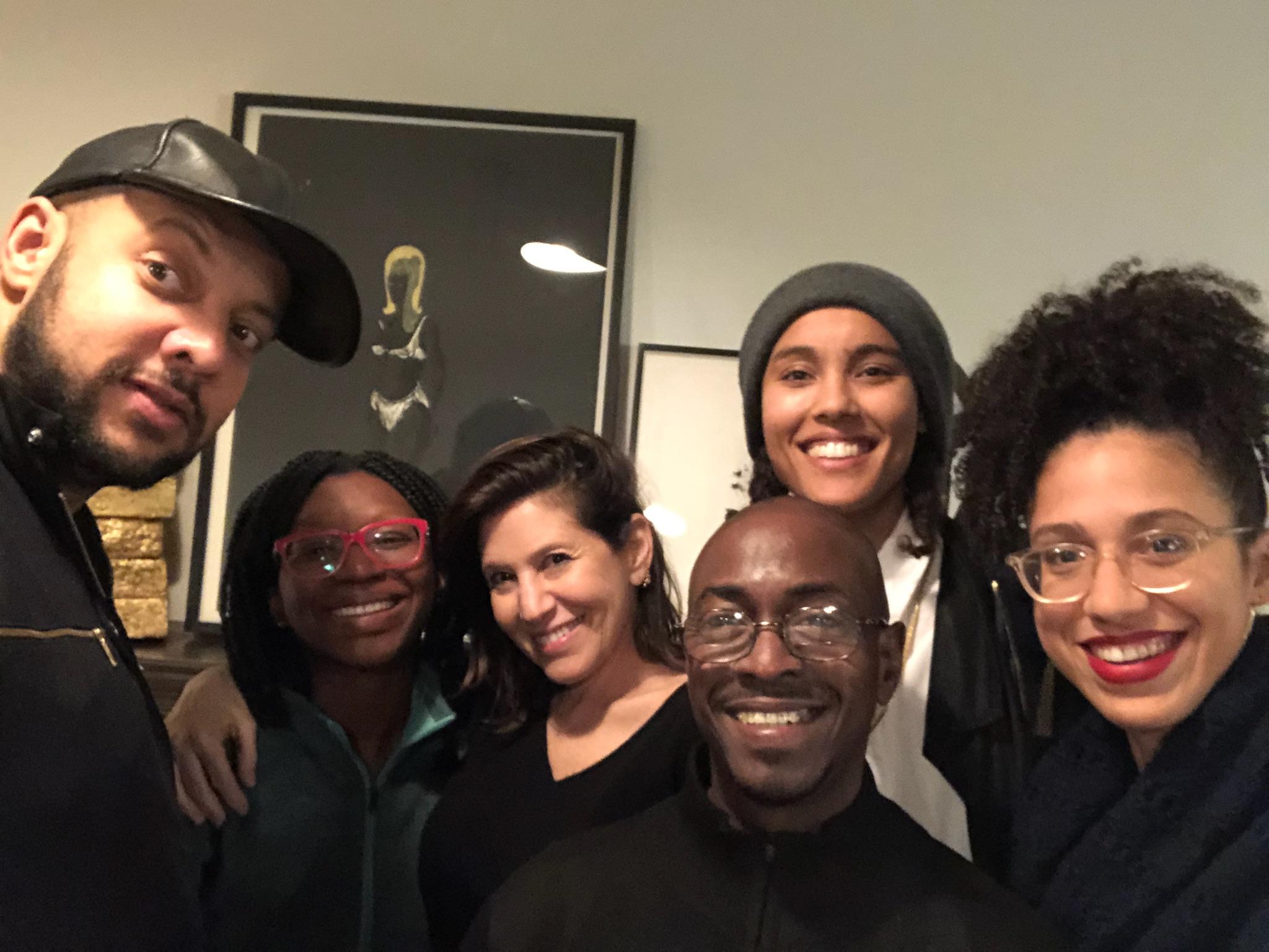 Six smiling people cluster together to pose for a group self portrait.