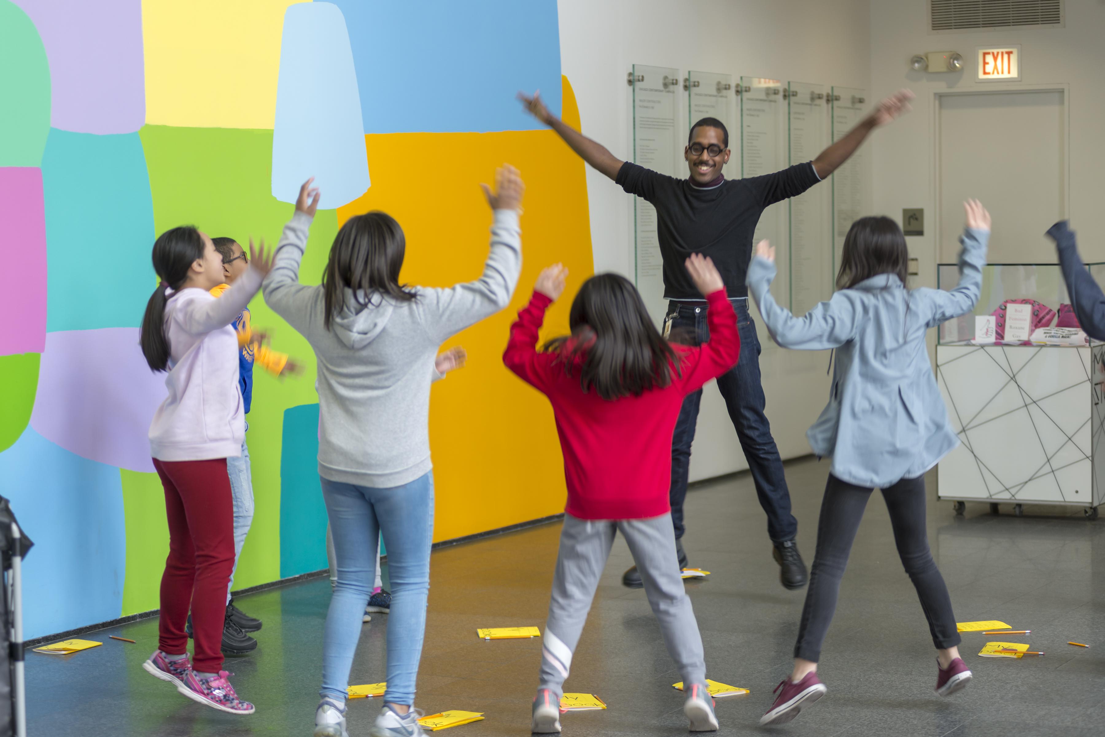 students and artist guide performing movement exercises