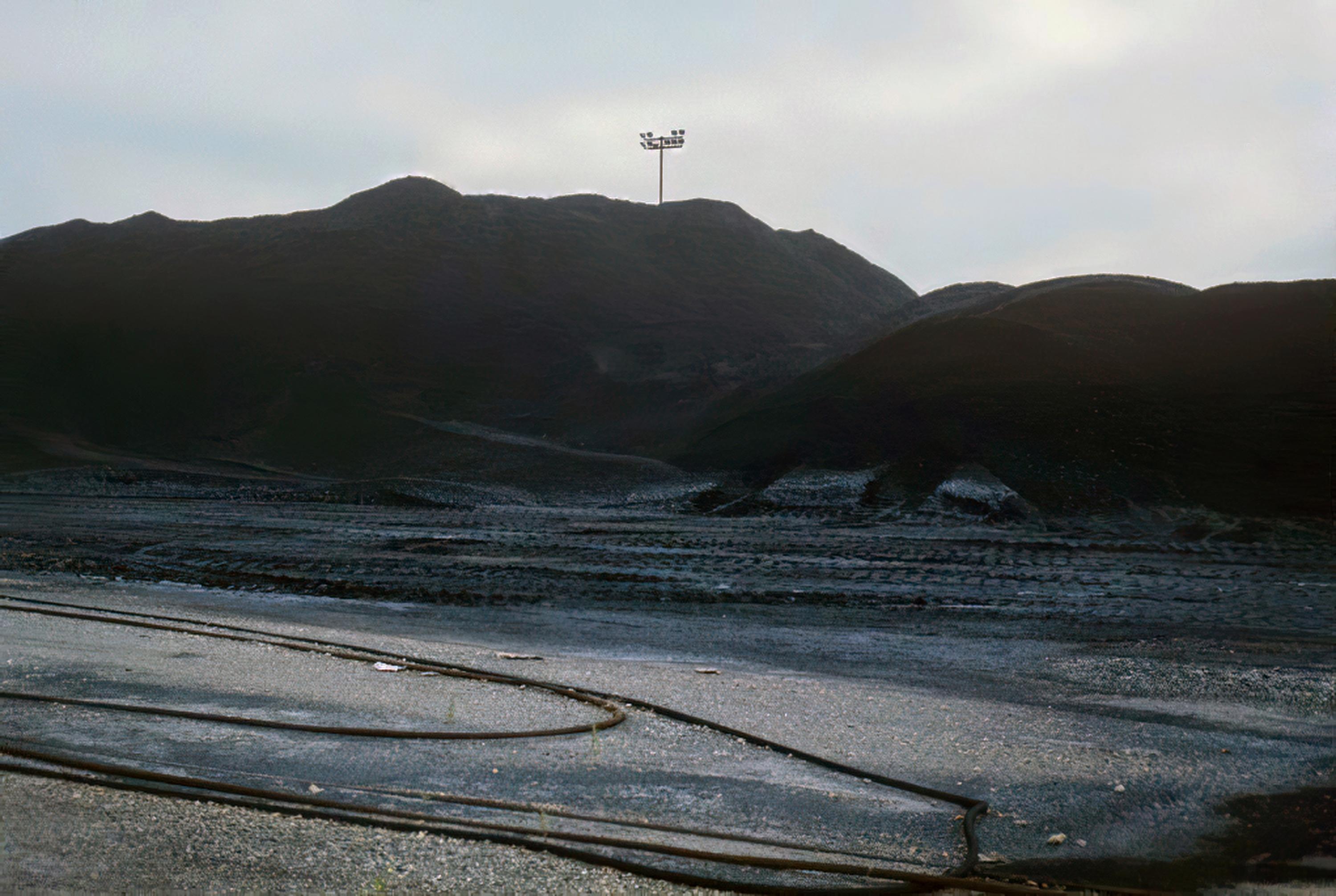 A grainy photo of massive hills of coal.