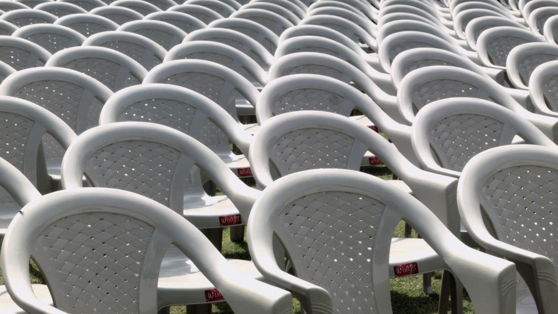 Plastic lawn chairs lined up fill the frame