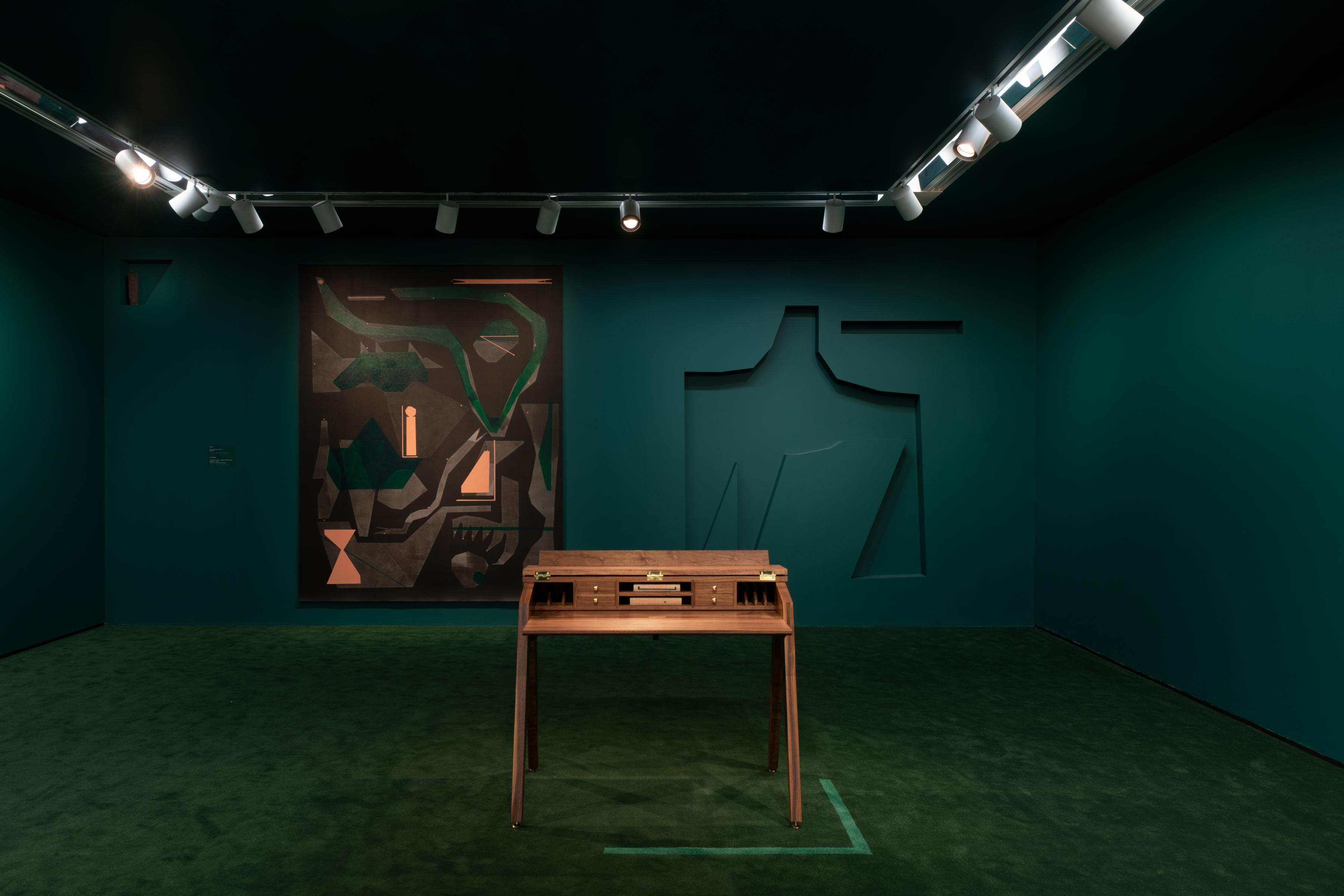 Dark green room with wood table and a dark gestural painting hanging on the wall