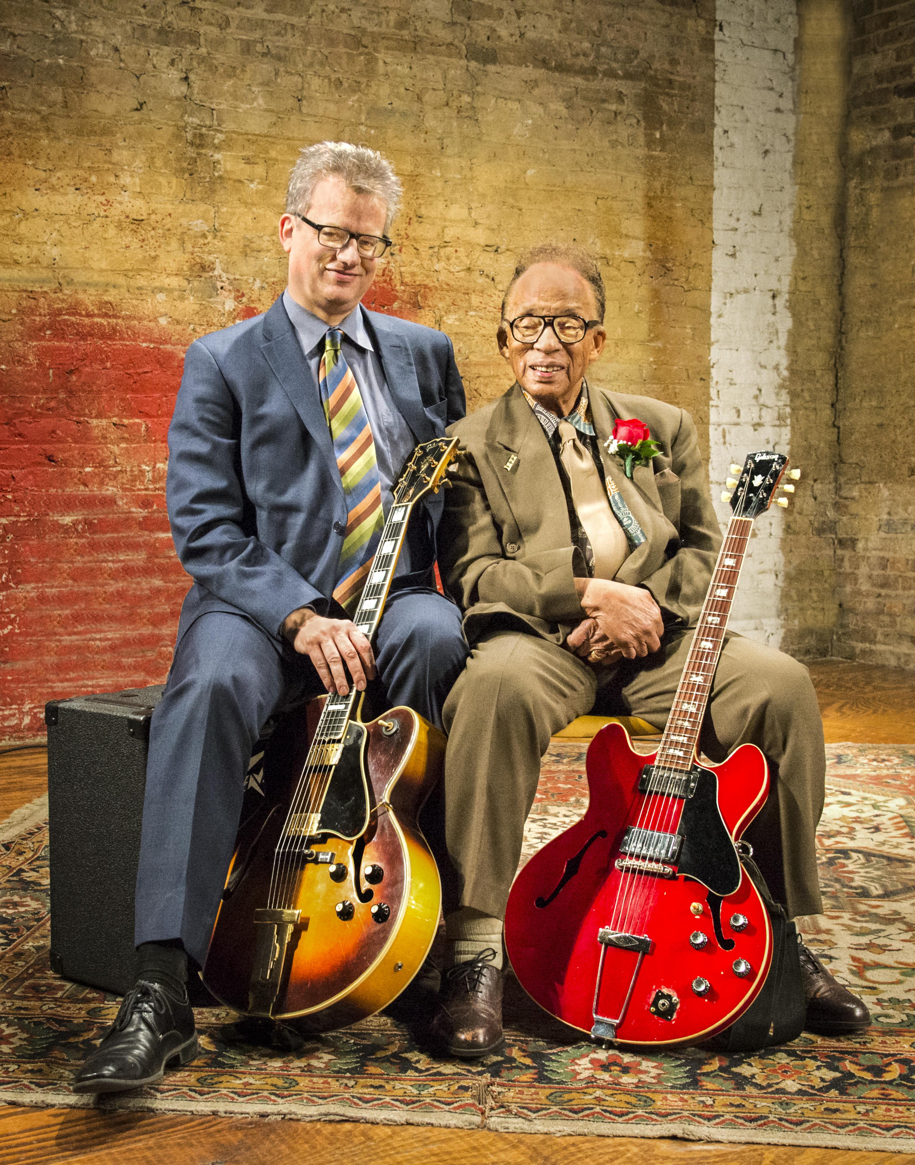portrait of Mike Allemana and George Freeman seated with their guitars