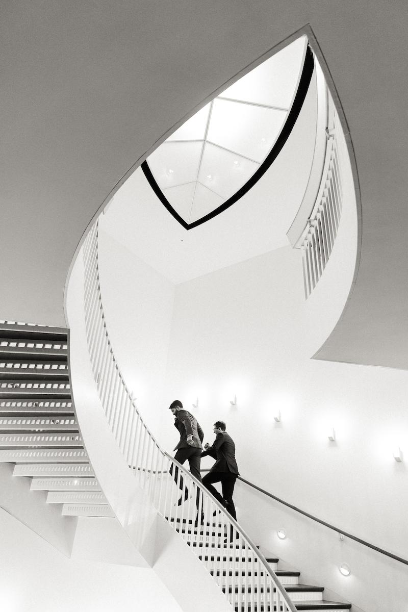 A couple is photographed holding hands while running up the iconic MCA staircase
