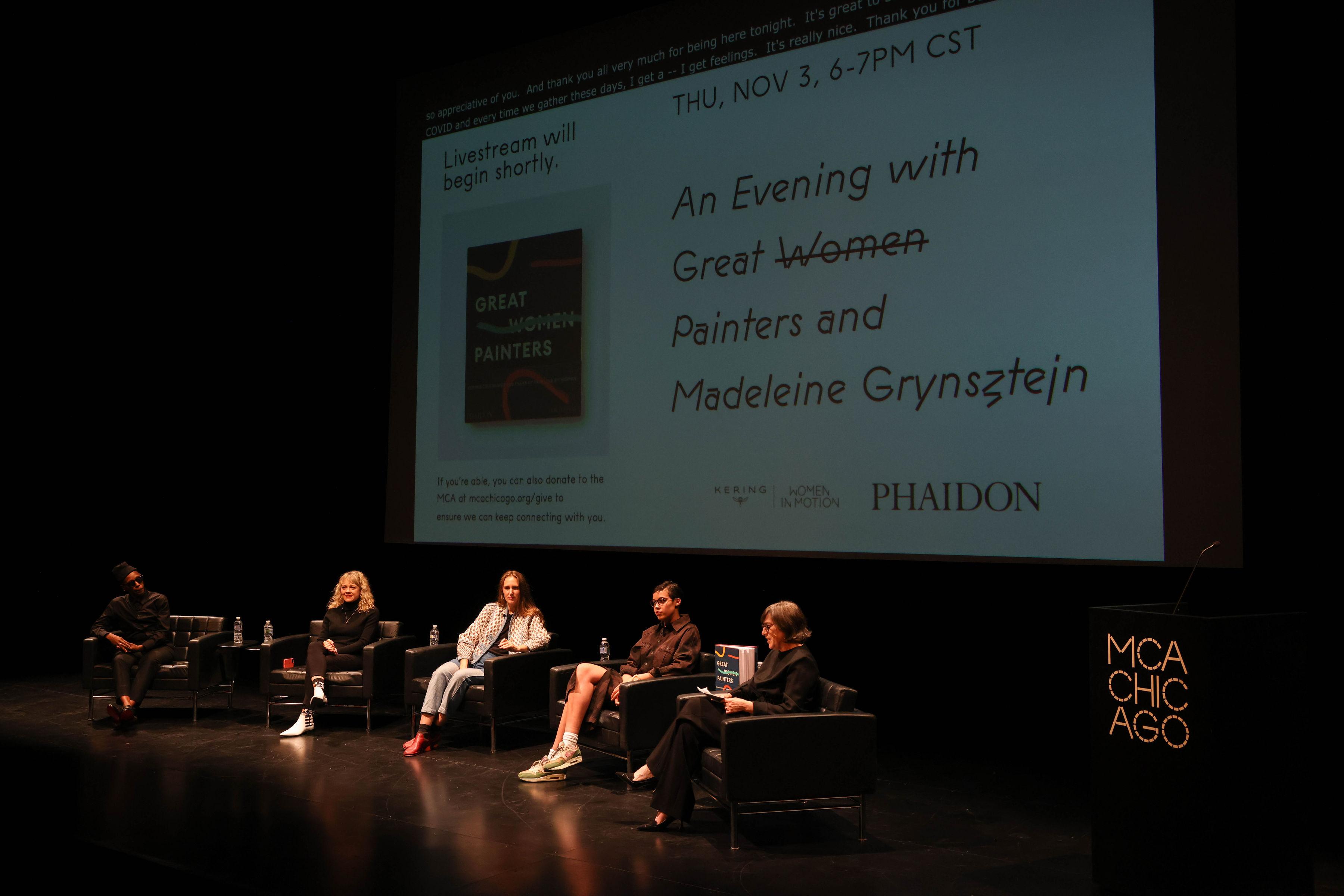 Panel seated for a talk in front of projection