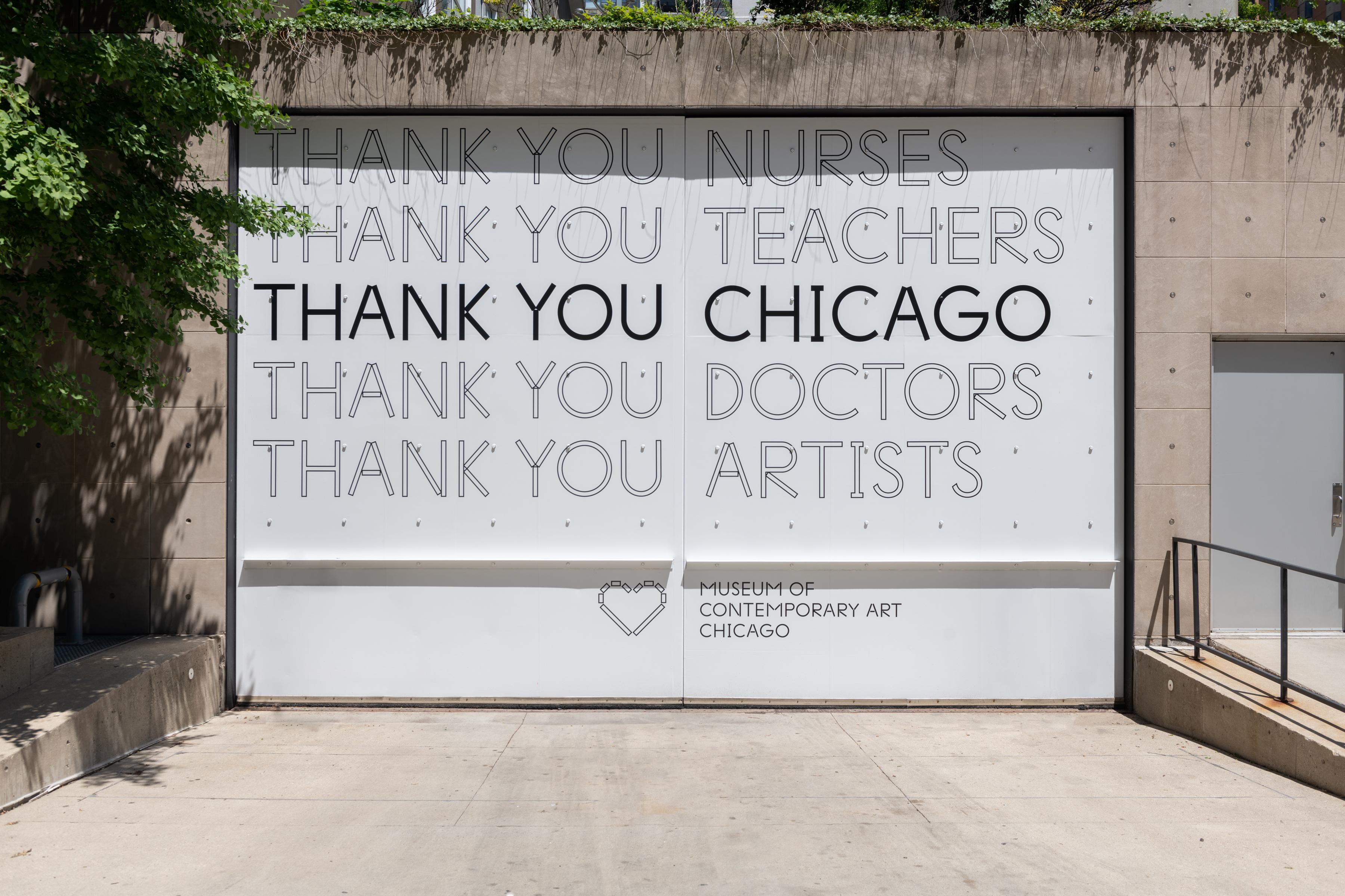 A large garage door with a full decal of text expressing thanks to Nurses, Teachers, Chicago, Doctors, and Artists.