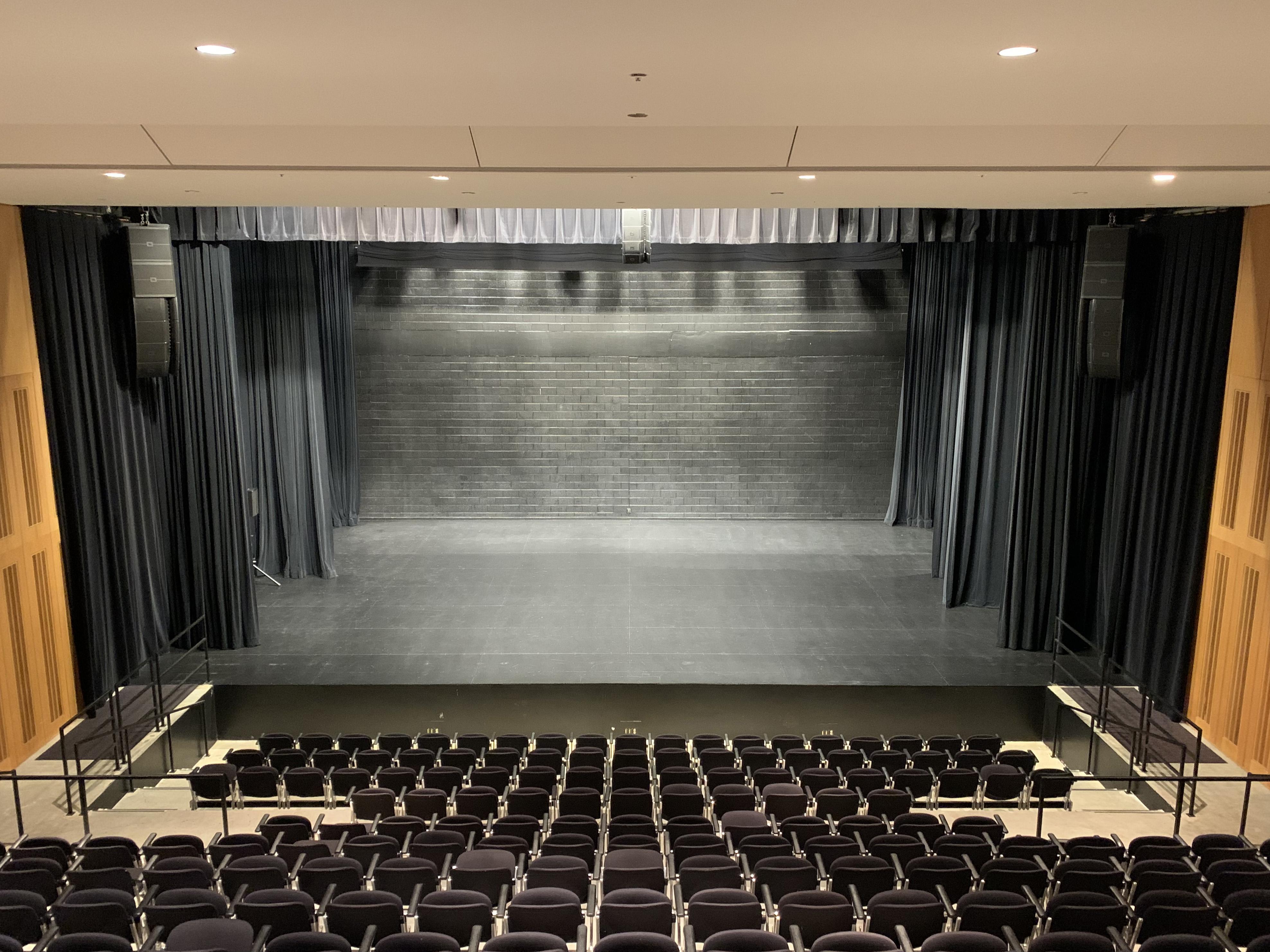 View from back of theater towards an empty, black stage
